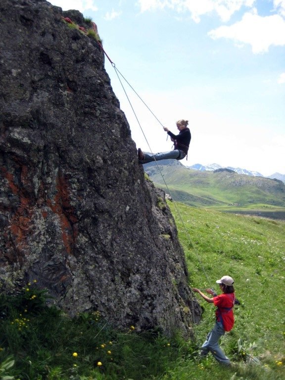 Jugendliche sichern beim Klettern an einer Felswand