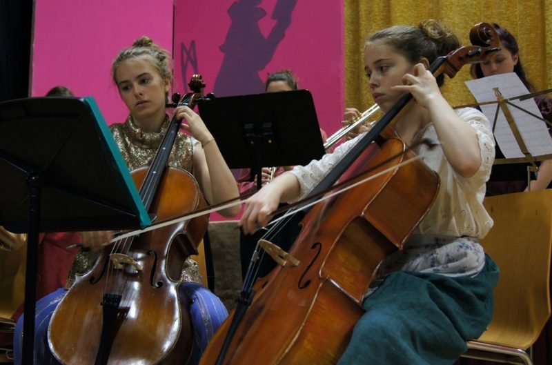 Schülerinnen und Schüler begleiten die Aufführung am Cello